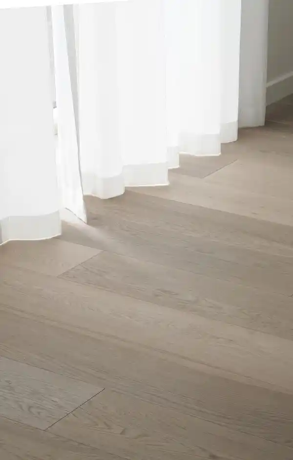 Light and airy Scandinavian living room with minimalist wood flooring, showcasing a clean aesthetic.